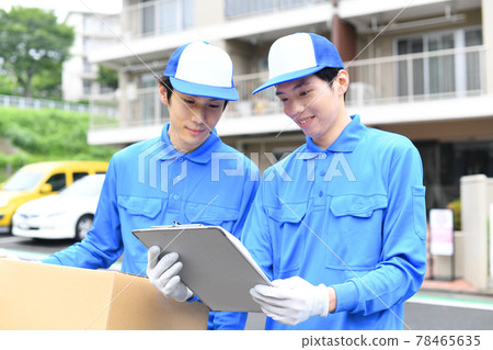Image of multiple men wearing work clothes carrying moving cardboard outdoors Image of multiple men wearing work clothes carrying moving cardboard outdoors 78465635