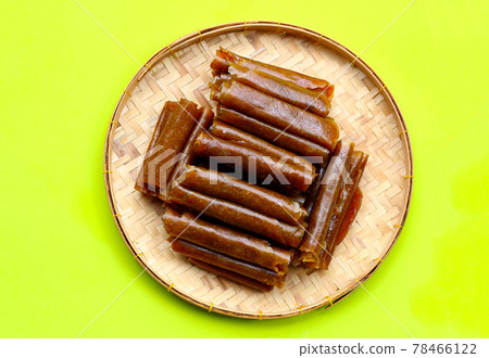Dried mango paste in bamboo basket on green background. Dried mango paste in bamboo basket on green background. 78466122