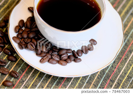 Coffee cups and beans on a tablecloth Coffee cups and beans on a tablecloth 78467003