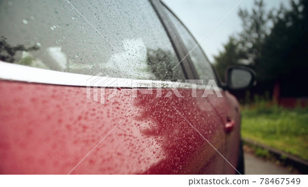 Rain drops on the side a red car on a rainy day Rain drops on the side a red car on a rainy day 78467549