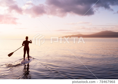 Adventurous girl on a paddle board is paddeling in the Pacific West Coast Ocean Adventurous girl on a paddle board is paddeling in the Pacific West Coast Ocean 78467968