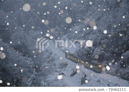 JR Iiyama Line train running in a snowy valley in Ojiya City, Niigata Prefecture 78468151