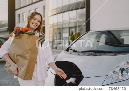 Woman charging electro car at the electric gas station Woman charging electro car at the electric gas station 78468450