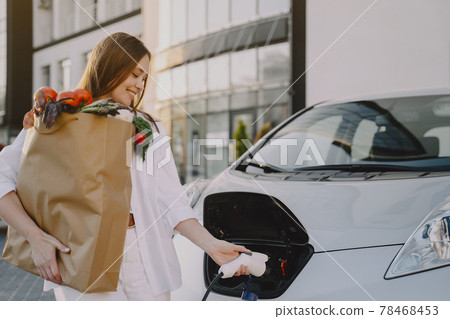 Woman charging electro car at the electric gas station 78468453