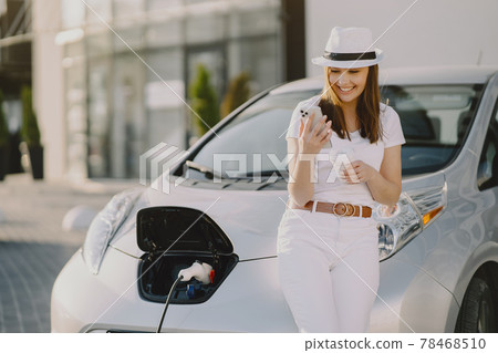 Woman charging electro car at the electric gas station Woman charging electro car at the electric gas station 78468510