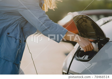 Woman charging electro car at the electric gas station Woman charging electro car at the electric gas station 78468514