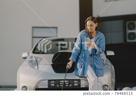 Woman charging electro car at the electric gas station Woman charging electro car at the electric gas station 78468515
