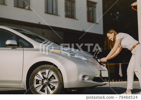 Woman charging electro car at the electric gas station 78468524