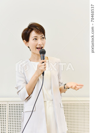 A woman speaking with a microphone at a seminar A woman speaking with a microphone at a seminar 78468537