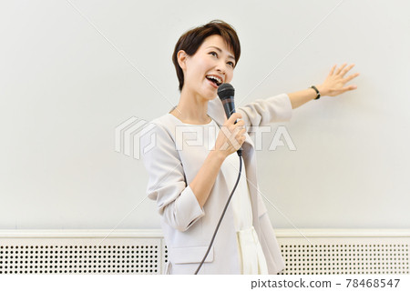 A woman speaking with a microphone at a seminar A woman speaking with a microphone at a seminar 78468547