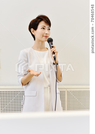 A woman speaking with a microphone at a seminar A woman speaking with a microphone at a seminar 78468548