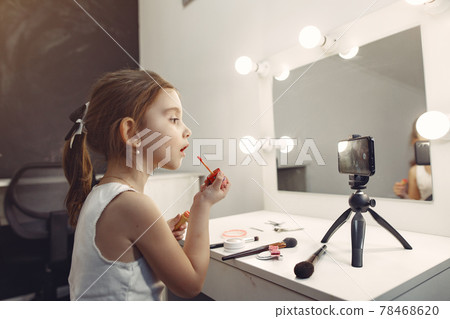 Cute little blogger with cosmetics recording video at home 78468620