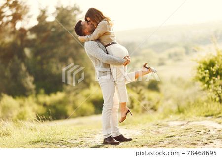 Beautiful couple spend time on a summer field Beautiful couple spend time on a summer field 78468695
