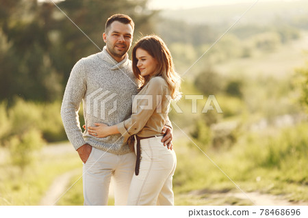 Beautiful couple spend time on a summer field Beautiful couple spend time on a summer field 78468696