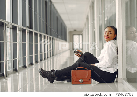 Black woman standing in the office with a laptop 78468795