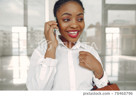 Black woman standing in the office with a laptop 78468796