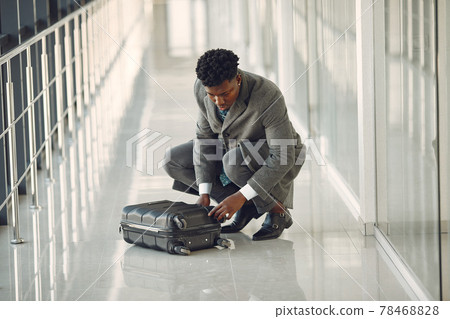 Elegant black man at the airport with a suitcase Elegant black man at the airport with a suitcase 78468828