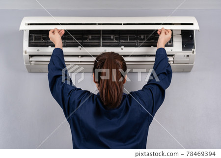 female technician service open air conditioner indoor for checking and repairing 78469394