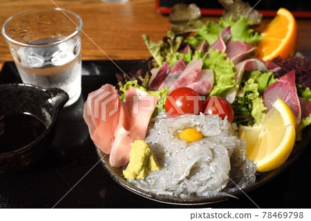 Bowl of rice topped with sashimi  78469798