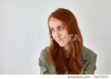 Shy woman with freckled skin and ginger hair 78471933