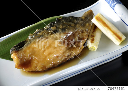 Photographed yellowtail teriyaki and grilled green onions with bamboo leaves on a black background 78472161
