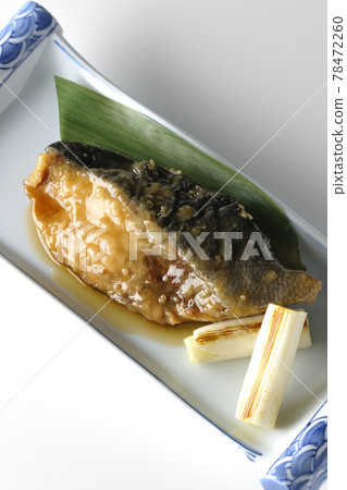 A bird's-eye view of yellowtail teriyaki and grilled green onions with bamboo leaves on a white background 78472260