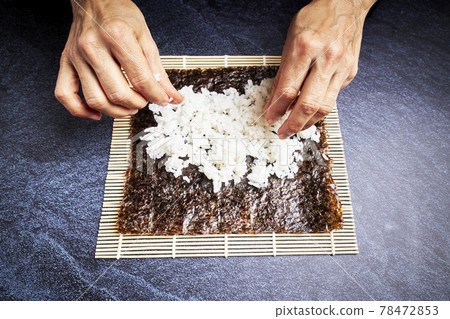 Female chef preparing rice on nori for delicious sushi. Asian food concept 78472853