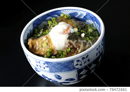 Photographed a teriyaki bowl of yellowtail topped with hot balls and plenty of small onions on a black background 78472881