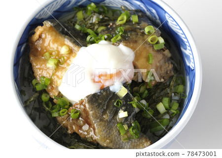 A bird's-eye view of a yellowtail teriyaki rice bowl topped with hot balls and plenty of small onions on a white background 78473001