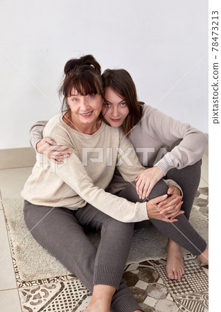 Mother and daughter in woolen clothes white background 78473213