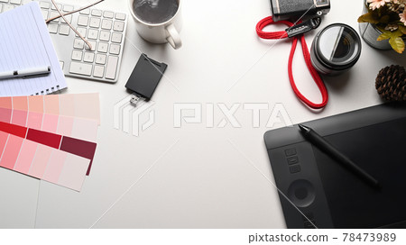 Graphic designer workspace with camera, graphic tablet, coffee cup and color swatch on white table. 78473989