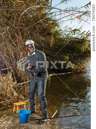 Man and pulling fish near river Man and pulling fish near river 78474883