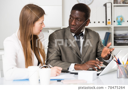 Young woman and man colleagues working with laptop and papers Young woman and man colleagues working with laptop and papers 78475264