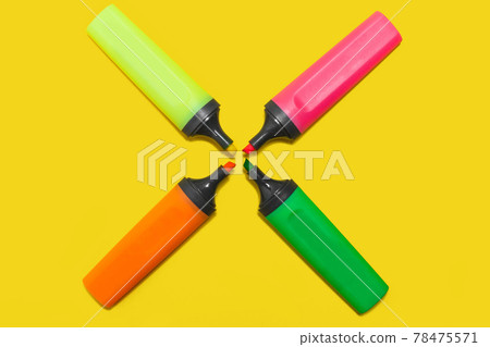 four office plastic markers on a yellow surface four office plastic markers on a yellow surface 78475571