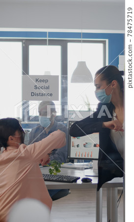 Coworkers touching elbow to avoid infection with coronavirus 78475719