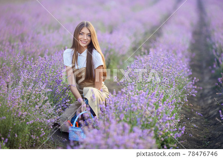 Smiling woman posing with basket in lavender field. Smiling woman posing with basket in lavender field. 78476746