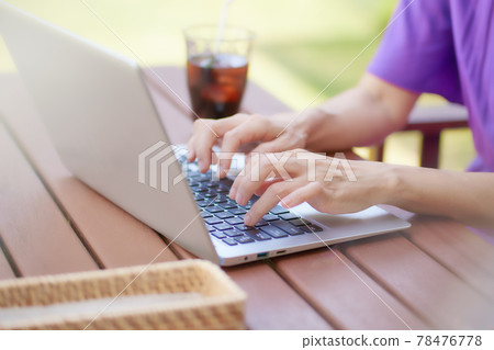 Business image A middle-aged woman hitting a computer at a cafe Business image A middle-aged woman hitting a computer at a cafe 78476778