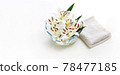 Transparent vase with water and white lilies with a white towel. Isolated on white. Spa concept for cleanliness, freshness and aromatherapy. 78477185