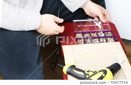 The man works as a drill in the workshop The man works as a drill in the workshop 78477554