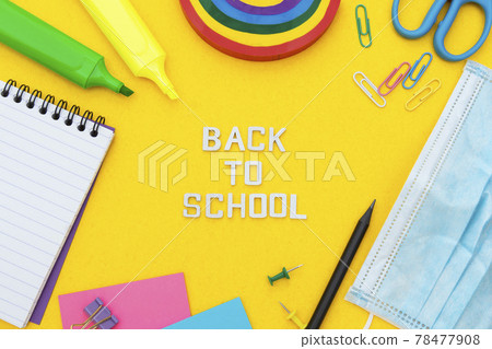 Back to school words. Face mask, colorful pencils, rainbow eraser, notebook, sticky notes and office supplies. Flat lay. Abstract educational background. Back to school words. Face mask, colorful pencils, rainbow eraser, notebook, sticky notes and office supplies. Flat lay. Abstract educational background. 78477908
