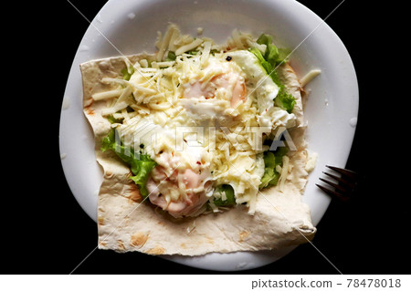 A dish of eggs. Fried eggs with pita bread, lettuce and cheese on a white and black plate. A dish of eggs. Fried eggs with pita bread, lettuce and cheese on a white and black plate. 78478018