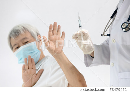 Doctor prepares to vaccinate,old senior refusing to receive a Coronavirus vaccine,uneasiness of elderly about medication quality or side effects after vaccination,insecure,distrust of COVID-19 vaccine Doctor prepares to vaccinate,old senior refusing to receive a Coronavirus vaccine,uneasiness of elderly about medication quality or side effects after vaccination,insecure,distrust of COVID-19 vaccine 78479451