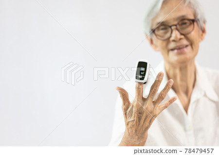 Hand of senior woman with an attached pulse oximeter on fingertip,old elderly measuring heart rate,checking oxygen saturation level in the blood,diagnosis of Coronavirus,COVID-19 at home,health care Hand of senior woman with an attached pulse oximeter on fingertip,old elderly measuring heart rate,checking oxygen saturation level in the blood,diagnosis of Coronavirus,COVID-19 at home,health care 78479457