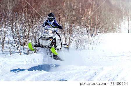 Snowmobile in high jump above track. Selective focus Snowmobile in high jump above track. Selective focus 78480964