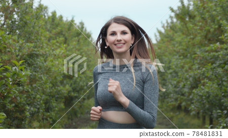 Front Follow up Shot of Girl Athlete Running Alone Down, Getting Ready for a Race Competition or Marathon. Test of Human Endurance. Young Fit Woman in Sportswear Jogging Alone. Slow Motion 78481831