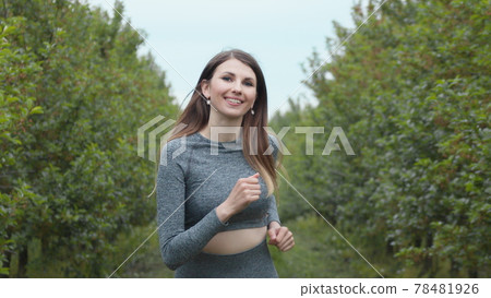 Front Follow up Shot of Girl Athlete Running Alone Down, Getting Ready for a Race Competition or Marathon. Test of Human Endurance. Young Fit Woman in Sportswear Jogging Alone. Slow Motion Front Follow up Shot of Girl Athlete Running Alone Down, Getting Ready for a Race Competition or Marathon. Test of Human Endurance. Young Fit Woman in Sportswear Jogging Alone. Slow Motion 78481926