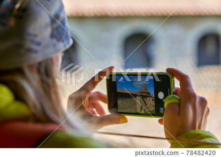 girl photographs the landmark on a mobile phone. Fortress Oreshek girl photographs the landmark on a mobile phone. Fortress Oreshek 78482420