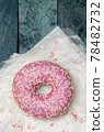 Donut with sugar sprinkles on a turquoise wooden background 78482732