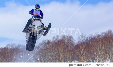 Snowmobile in high jump above track. Selective focus Snowmobile in high jump above track. Selective focus 78483050