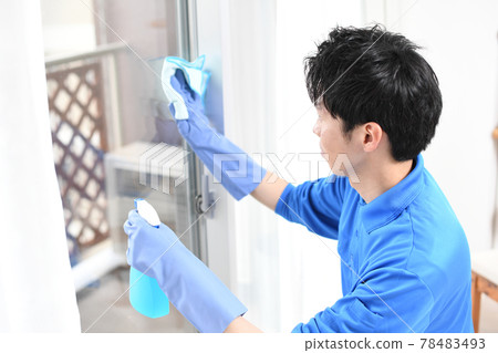 Young man in work clothes for cleaning industry cleaning windows Young man in work clothes for cleaning industry cleaning windows 78483493